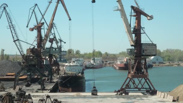 タグボート ・貨物港の造船所でクレーンの風景です。ターミナルで貨物船の建材のクレーン荷重 — ストック動画