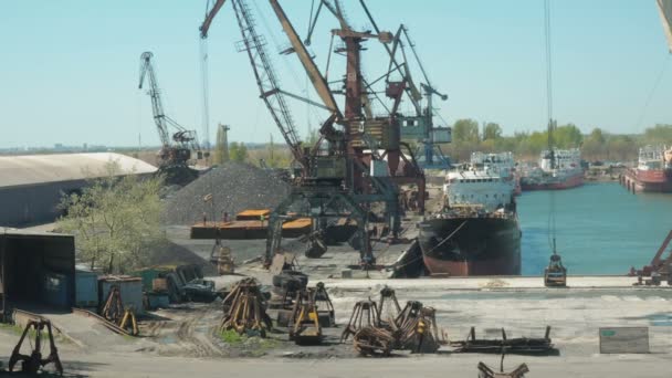 Paisaje de remolcadores y grúas en astillero en puerto de carga. Carga de grúas de material de construcción en un buque de carga en una terminal — Vídeos de Stock