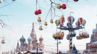 Kızıl Meydan 'daki Moskova Kremlin' deki Noel panayırında dönen atlıkarınca. Noel perisi aydınlandı. Parlak döner kavşaklar dönüyor. St. Basils Katedrali veya Vasily Katedrali