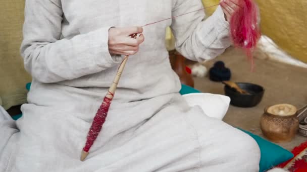 Woman in medieval cotton dress spinning with a wheel. Lady makes yarn from a sheeps wool. Hand spindles. Spinning Wheel. Spinning yarn. Process twisting fibers wool, flax, hemp, cotton into yarn — Stock Video