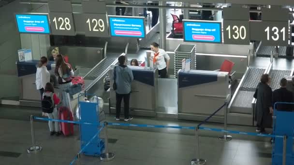 Moszkva, Oroszország - 2019. augusztus 8.: Vnukovo nemzetközi repülőtér. Az utasok és a poggyász regisztrációja a járaton. A repülőtéri biztonsági személyzet ellenőrzi a személyek személyazonosságát a bejelentkezéskor, vagy — Stock videók