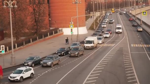 Moskva, Ryssland - 23 november 2019: Utsikt från Big Stone Bridge till Moskvoretskaja vall nära Kreml i Moskva vid solnedgången. Trafiken i en storstad. Förflyttning av bilar på en motorväg med bredband — Stockvideo