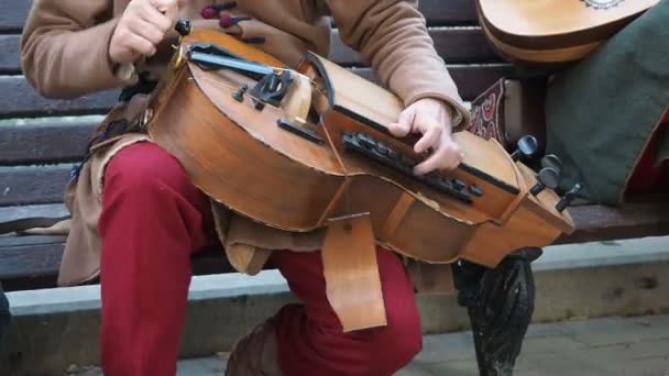 มอสโก รัสเซีย 13 มิถุนายน ค.ศ. 2019: นักดนตรีข้างถนน แต่งตัวด้วยเสื้อผ้าวินเทจเชื้อชาติตะวันออก เล่นดนตรีบนเครื่องดนตรีตะวันออกกลางแบบดั้งเดิม hurdy-gurdy ยังตั้งชื่อว่า wheel fiddle, wheel vielle — วีดีโอสต็อก
