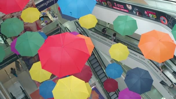 Pyatigorsk, Rusia - 30 de agosto de 2019: Muchos paraguas de colores brillantes suspenden en el centro comercial Galería. Hermosos paraguas multicolores colgando en una vista superior del centro comercial. Fondo abstracto colorido — Vídeo de stock