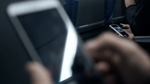 사람들은 대중교통을 이용하고 휴대 전화를 이용합니다. 한 남자가 클로즈업했을 때 스마트폰을 들고 있었습니다. 한 남자가 지하철에 앉아 있는 동안 전화번호부에서 얼마의 정보를 읽는다. 전면 사진 — 비디오
