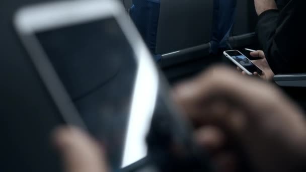 La gente viaggia con i mezzi pubblici e guarda i telefoni cellulari. Smartphone nelle mani di un uomo primo piano. Un uomo legge alcune informazioni sullo schermo del telefono mentre è seduto nella metropolitana. Visualizzazione primo piano — Video Stock