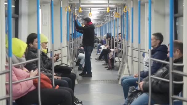 MOSCÚ, RUSIA - 21 DE NOVIEMBRE DE 2019: Movimiento del tren metro. La gente en ropa de abrigo sentado en el vagón subterráneo un uso de teléfonos inteligentes. Un hombre sentado pensando en algo, Chica y mujer — Vídeos de Stock