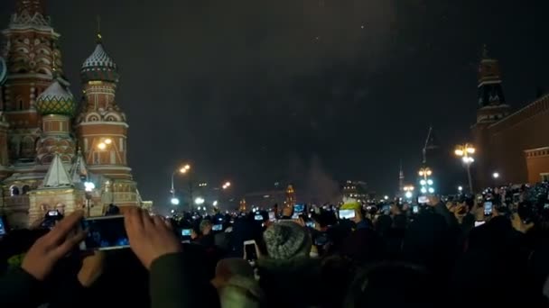 Moskou, Rusland -1 januari 2019: Veel mensen kwamen samen voor een universeel nieuwjaar in Moskou. Vuurwerk op het Rode Plein in de buurt van de Spasskaya toren op oudejaarsavond. Veelkleurige groet in de — Stockvideo