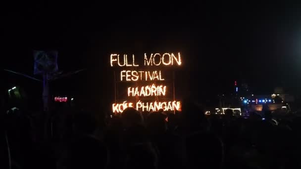 Koh Phangan, Tajlandia-22 grudnia 2018: Full Moon Party znak ognia na plaży Haad Rin na wyspie Koh Phangan, Tajlandia. Dziewczyny i faceci tańczą w imprezie Full Moon na piaszczystej plaży w pobliżu ognia szyld — Wideo stockowe