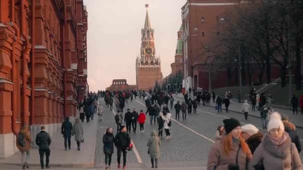 MOSCÚ, RUSIA - 23 DE NOVIEMBRE DE 2019: Moscovitas e invitados de la capital de Rusia caminan por el pasaje del Kremlin, observando los lugares de interés de Moscú. Torre Spasskaya en el fondo — Vídeos de Stock