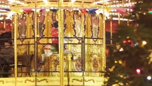 MOSCOW - DECEMBER 25, 2017: People on beautiful golden carousel near Red Square decorated and arranged for Christmas New Year. Christmas fair. Luminous roundabout rotates with adults and childrens — Stock Video