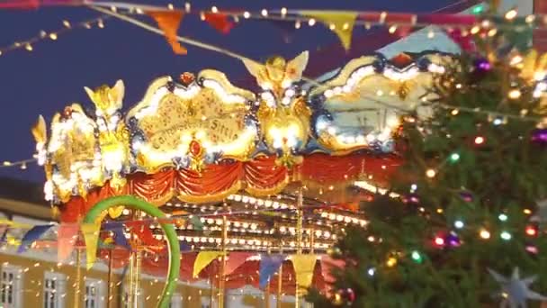 Beautiful illuminated merry-go-round details while rounding at Christmas fair in slow motion. Vintage colorful carousel with angel on the top — Stock Video