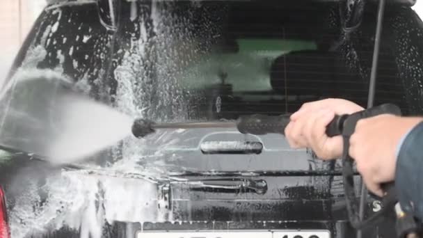 Процесс мойки автомобиля на автомойке самообслуживания. Реакция воды с высоким давлением смыть пену из окна заднего сиденья Rexton Ssang Yong — стоковое видео