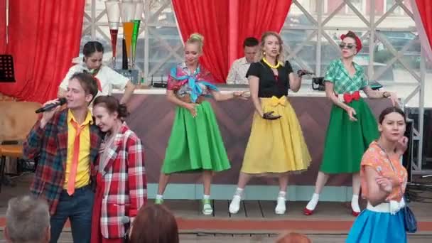 Moscou, Rússia - 20 de agosto de 2018: Festival de reencenação Tempos e épocas nas ruas de Moscou. Jovens vestindo roupas coloridas de moda antiga em estilo Pinup ou Stilyagi stile dançando em cena ao ar livre — Vídeo de Stock