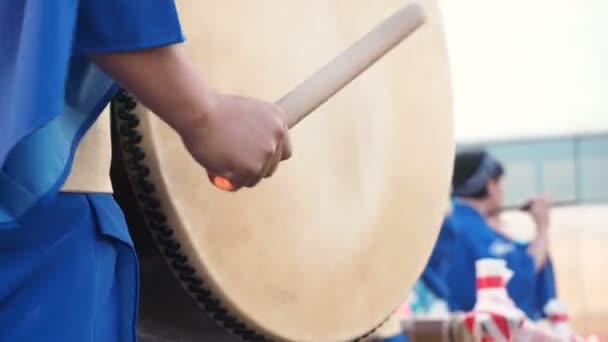 Японские музыканты играют на барабанах в японском фольклоре Taiko Drum hira-daiko. Японский артист выступает на фестивале Бон в синем кимоно с большим барабаном крупным планом — стоковое видео