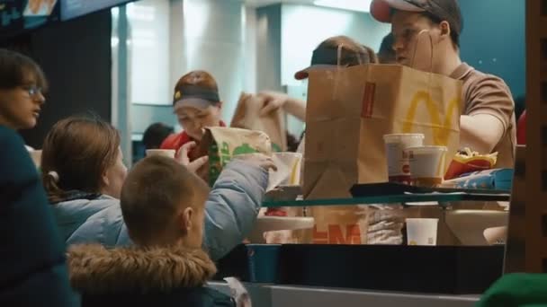 Moskwa, Rosja - 15 grudnia 2019: Kontrwywiad w McDonaldzie. Przyjazny menedżer Mcdonaldów zweryfikowany czekiem płatniczym i przyjmuje zamówienie do klienta. Skuteczne zarządzanie szybką żywnością — Wideo stockowe