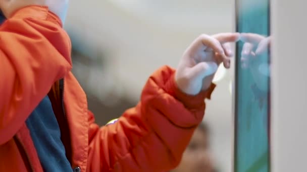 En mann som velger mat via en automat på gatekjøkken. Gutt som bruker berøringsterminal bestiller raskt gjennom selvbetjeningskiosken. Personen sveiper skjermen og bestiller på nettet. En mannlig hånd – stockvideo