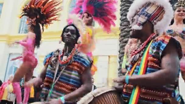 MOSCÚ, RUSIA - 29 DE FEBRERO DE 2020: Tambores africanos con ropas étnicas tocando el tambor de djembe de cerca. El músico late el ritmo en la batería africana. Artistas negros golpearon la batería con sus manos. Chicas. — Vídeo de stock