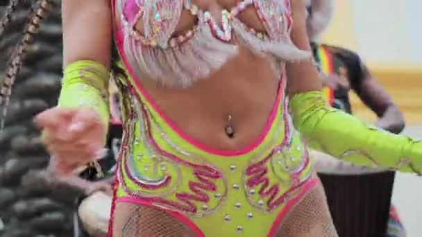MOSCÚ, RUSIA - 29 de FEBRERO de 2020: Hermosa chica brillante traje de carnaval colorido decorado con pedrería bailando samba. Bateristas africanos con ropas étnicas tocando el tambor djembe de cerca — Vídeo de stock