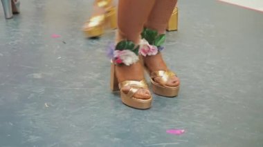 Altın sandaletli kadın bacakları Brezilya sambası yapıyor. Balıkçı çoraplı çekici bir kabare dansçısının kadın bacakları. Topuklu ayakkabılı kadın ayakları. Dansçı bacakları Dans pistinde topuklu sandaletler.