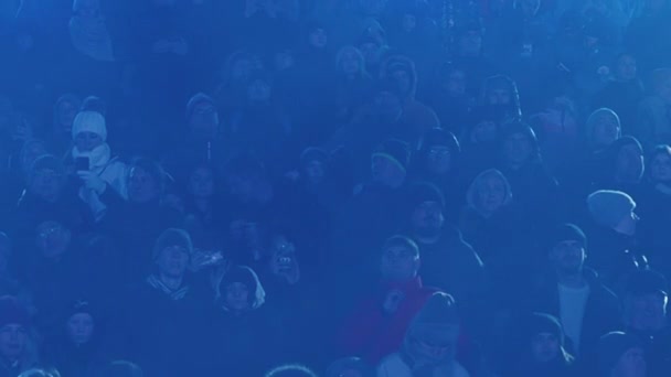 Москва, Россия - 15 февраля 2020 года: Толпа стоит в тени в синем тумане. Толпа зрителей на трибунах в тумане — стоковое видео