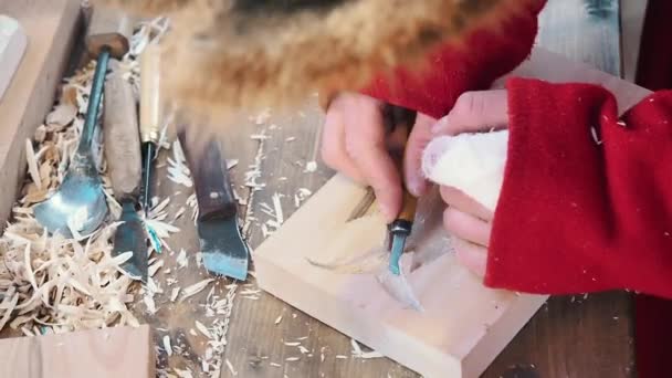 Ein Handwerker schnitzte mit einem Messer eine Backform Lebkuchen und Plätzchen aus Holz. Art Holzschnitzer stellt Holzschnitzereien her. Detail der arbeitenden Hände. Der Bildhauer stellt die Skulptur her. Traditionelles Handwerk — Stockvideo