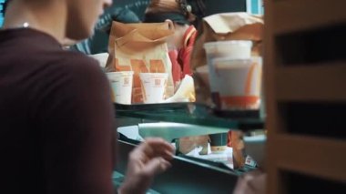Moskova, Rusya - 15 Aralık 2019: Müşteriler siparişlerini McDonalds restoranında sipariş verme alanında alıyorlar. McDonalds 'da sayaç servisi. McDonald 'ın samimi yöneticileri.