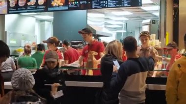 Moskova, Rusya - 15 Aralık 2019: McDonalds restoranında sipariş verme alanında hazır yemek bekleyen müşteriler. McDonalds 'da sayaç servisi. Dost canlısı yöneticiler.