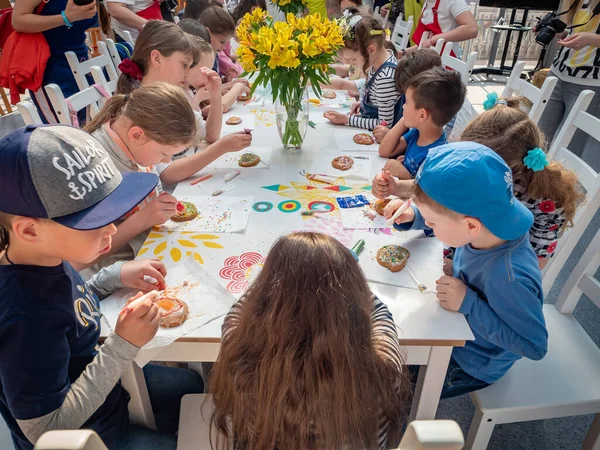 Russland, Moskau 26. April 2019: Meisterkurs auf dem Manegenplatz für Kinder zu Ostern. Vorschulkinder bei einem Meisterkurs zum Thema Lebkuchendekoration. Kinder lernen unter Aufsicht von Erwachsenen — Stockfoto