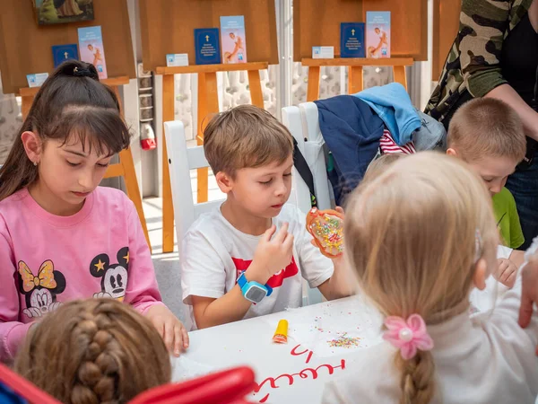 Russland, Moskau 26. April 2019: Meisterkurs auf dem Manegenplatz für Kinder zu Ostern. Vorschulkinder bei einem Meisterkurs zum Thema Lebkuchendekoration. Kinder lernen unter Aufsicht von Erwachsenen — Stockfoto
