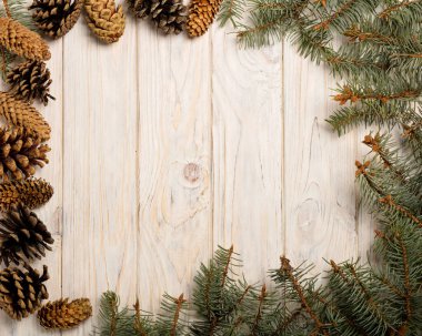 Beyaz ahşap tahta üzerinde koniler ile Noel çam dalları