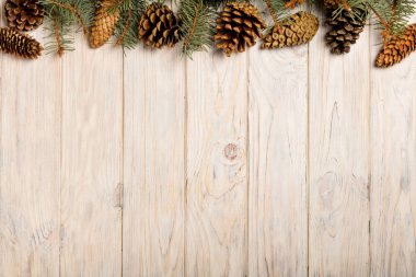 Beyaz ahşap tahta üzerinde koniler ile Noel çam dalları