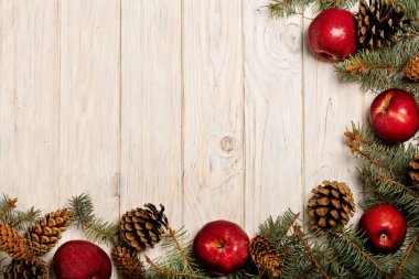 Noel elma ve beyaz tahta üzerinde koniler ile çam dalları 