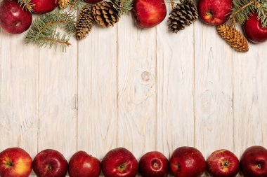 Noel elma ve beyaz tahta üzerinde koniler ile çam dalları 