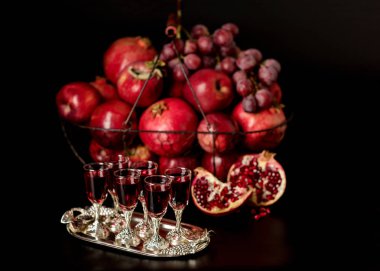 Karanlık bir arka plan üzerinde natürmort. Şarap (içki) gözlük, meyve bir