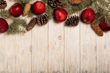 Noel elma ve beyaz tahta üzerinde koniler ile çam dalları 