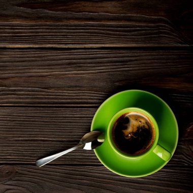Yeşil fincan kahve koyu ahşap arka plan üzerinde.