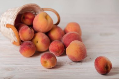 Hafif ahşap arka plan üzerinde bir sepet içinde lezzetli olgun şeftali. 