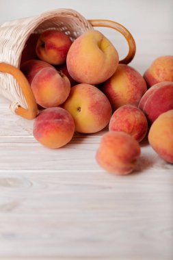Hafif ahşap arka plan üzerinde bir sepet içinde lezzetli olgun şeftali. 