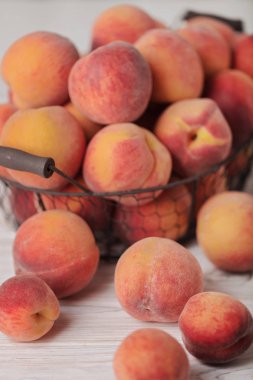 Hafif ahşap arka plan üzerinde bir sepet içinde lezzetli olgun şeftali. 