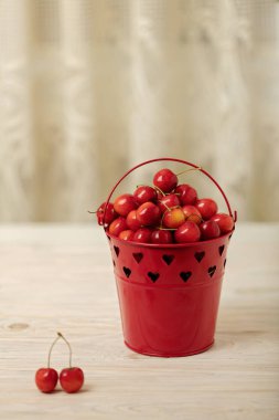Hafif ahşap arka plan üzerinde bir sepet içinde kiraz. 