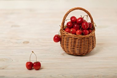 Hafif ahşap arka plan üzerinde bir sepet içinde kiraz. 