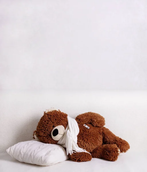 Teddy bears in warm scarves get sick and measure their temperatu
