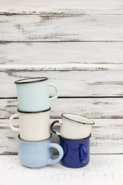 Eski ahşap arka planda retro tarzda emaye kupalar. 