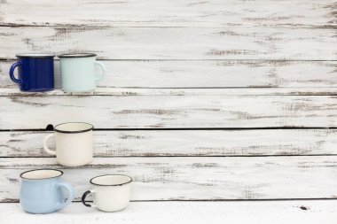 Eski ahşap arka planda retro tarzda emaye kupalar. 