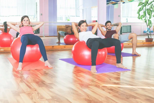 Grupp människor gör övning med fitness boll — Stockfoto