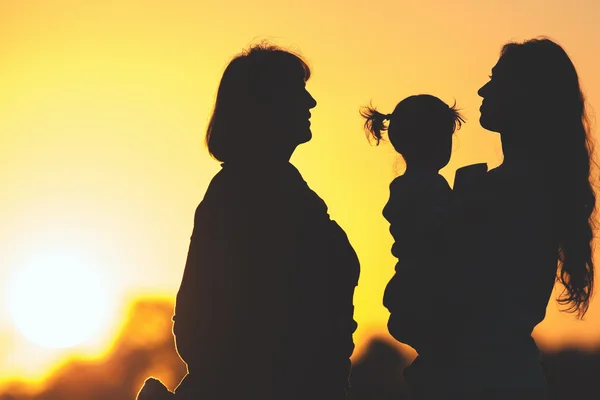 Silhouet gezin met dochter, moeder en grootmoeder buiten. Val seizoen — Stockfoto