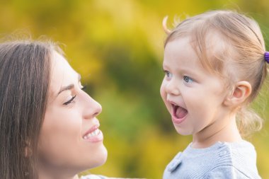 Komik bir çocuk açık tutan anne. Sonbahar renkleri arka plan