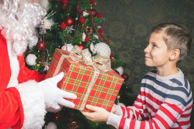 Mutlu çocuk ve büyük hediye kutusu ile Noel Baba! Mutlu Noeller!