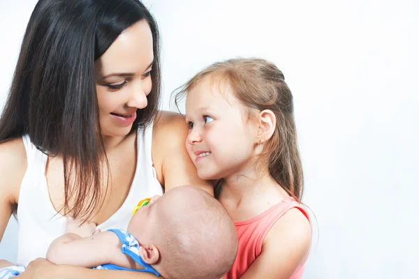 Mãe de família feliz com filha segurando bebê — Fotografia de Stock